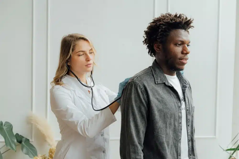 Doctor using stethoscope to examine patient lungs for persistent cough evaluation