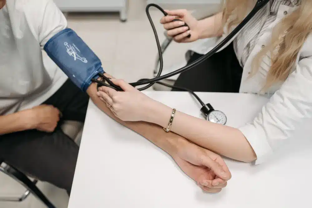 Nurse checking blood pressure during a DOT physical exam at a walk-in clinic