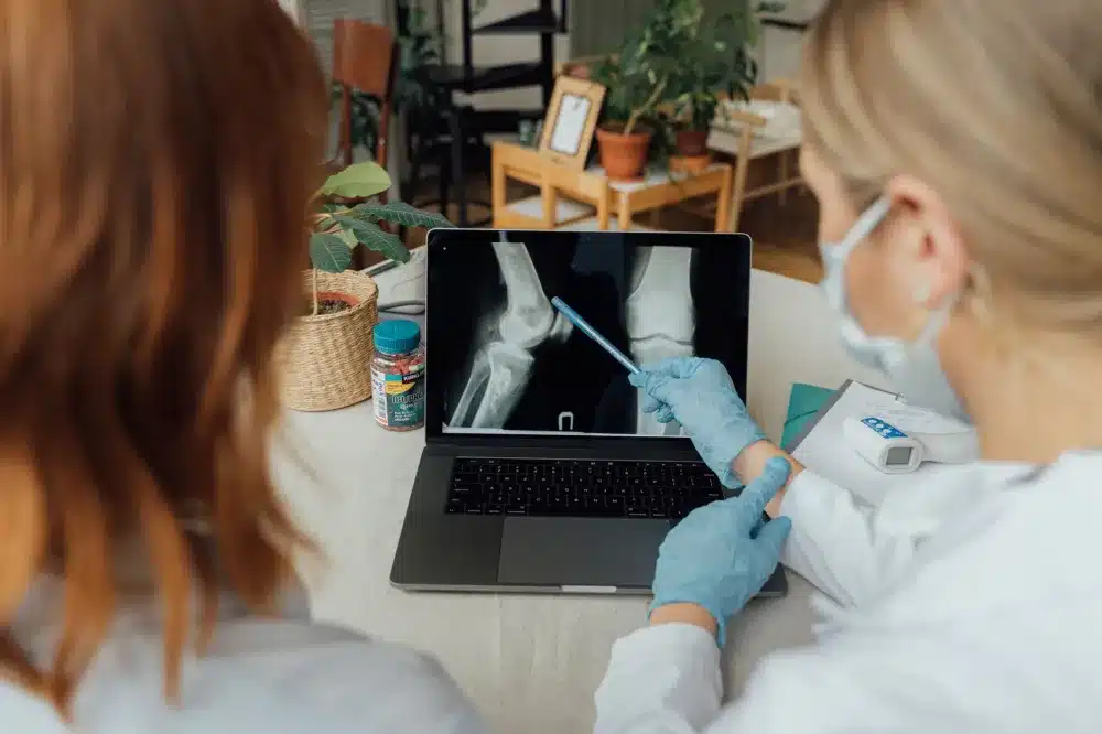 Doctor carefully examining a patient's swollen knee joint during a walk-in orthopedic visit