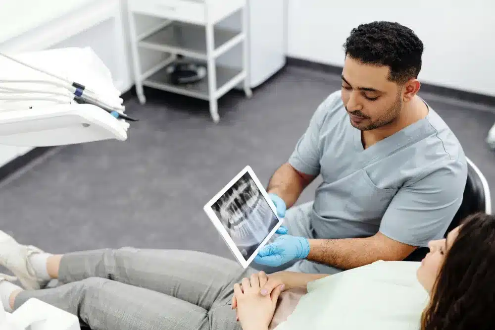 Technician reviewing a digital X-ray of a hip joint at an urgent care clinic