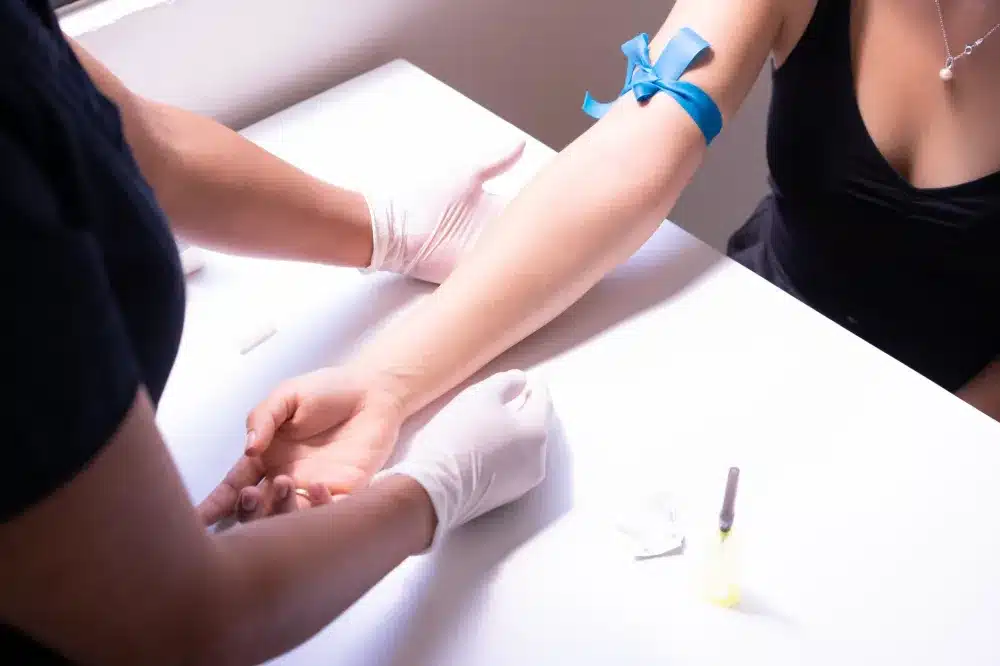 Lab technician drawing blood for autoimmune and inflammation marker testing