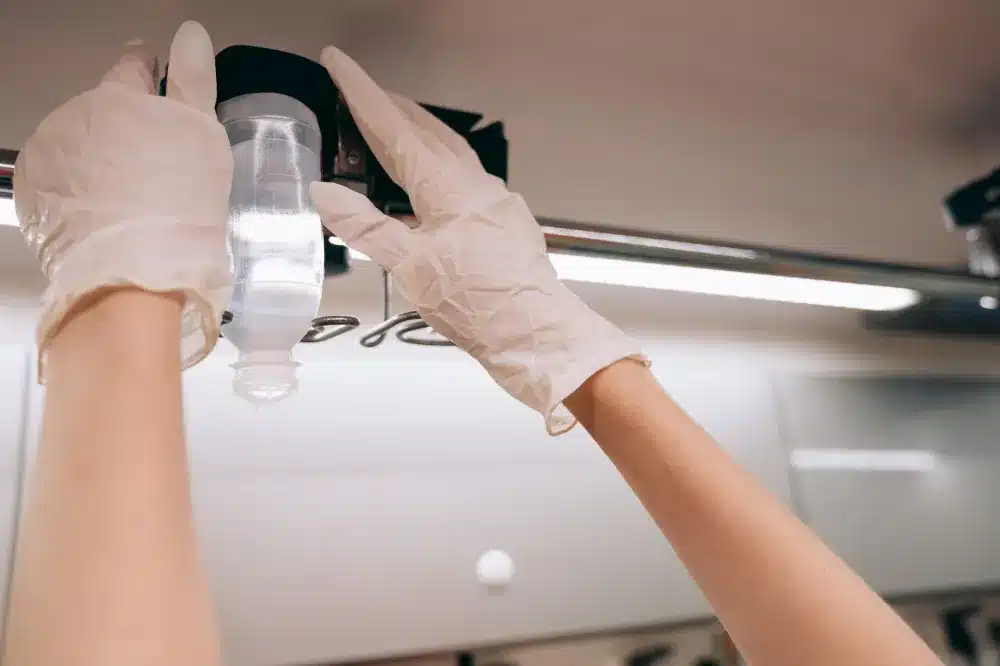 Nurse setting up intravenous IV hydration drip for a dehydrated patient at urgent care
