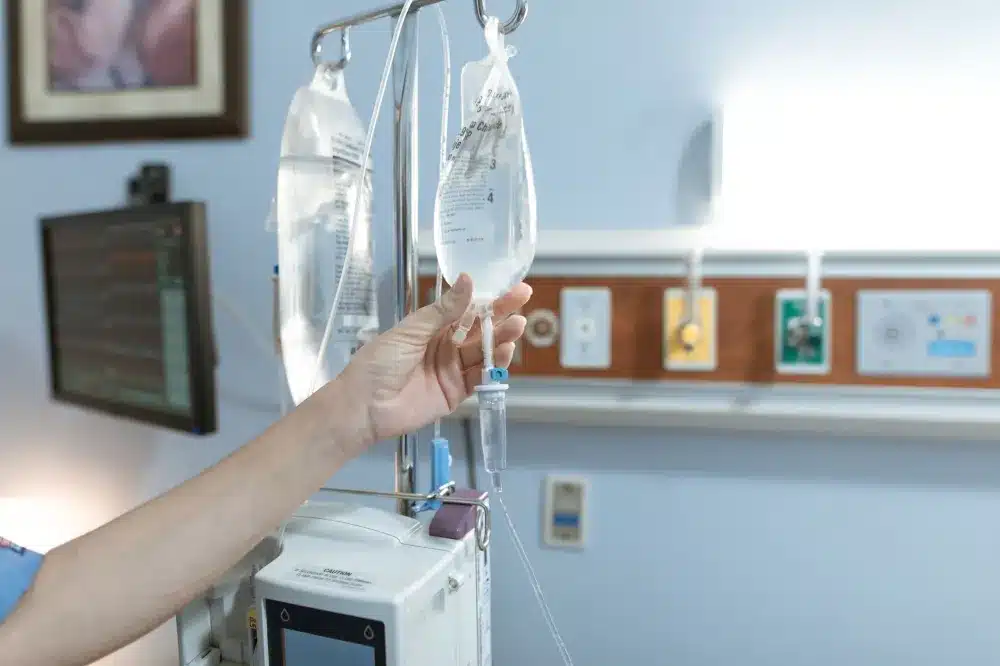 Nurse preparing IV hydration therapy for patient experiencing nausea and dehydration