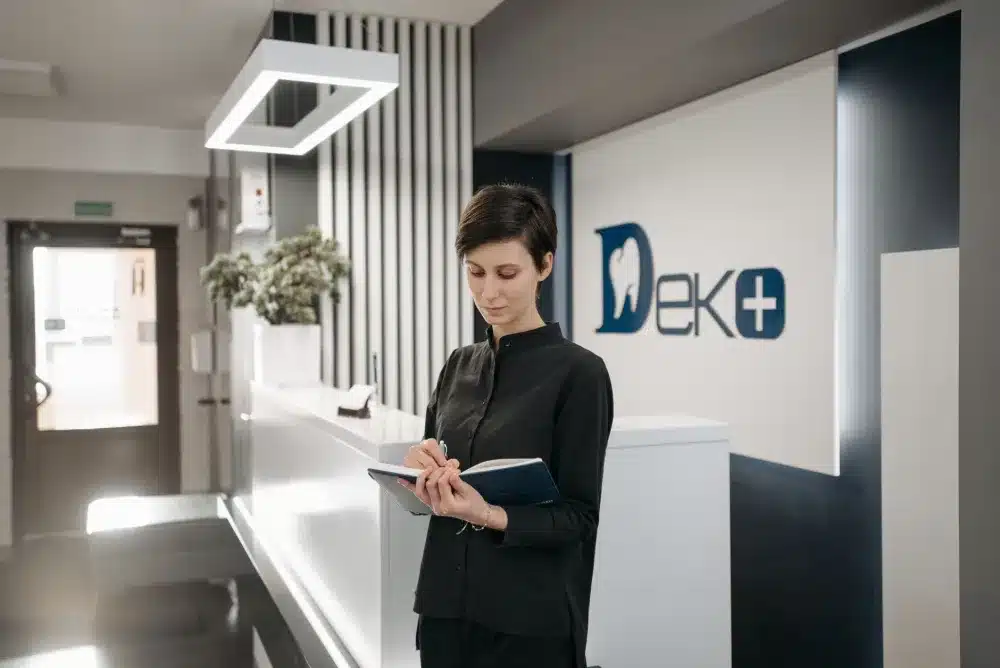 Friendly clinic front desk staff welcoming walk-in patient for women's health appointment